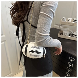 Detail of rugby-shaped crossbody bag with gold chain strap shown on a model