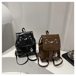 Detail of mini PU leather backpacks with cartoon cat face and paw prints in black and brown