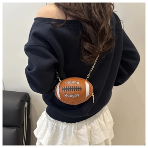 Detail of rugby-shaped mini crossbody bag with gold chain strap on a model's back