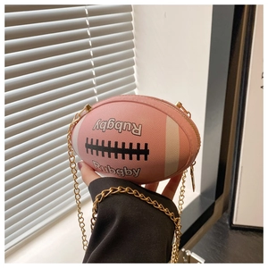 Detailed shot of pink rugby-shaped crossbody bag featuring textured faux leather and chain