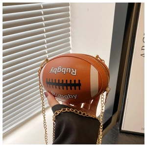 Close-up of orange-brown rugby shaped PU leather crossbody bag with gold chain strap