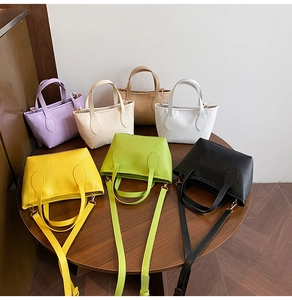 Detailed top view of assorted candy-colored litchi texture bucket bags on a wooden table