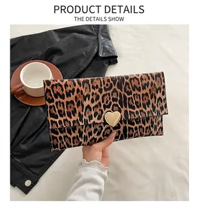 Détail de la pochette léopard avec un fermoir en métal doré en forme de cœur
