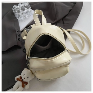Detalle del interior de la mini mochila de cuero PU crema con colgante de osito suave