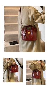 Detail of wine red patent leather handbag with adjustable strap and braided charm accent