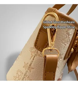Close-up of premium light gold hardware and star embossed leather texture on beige bag