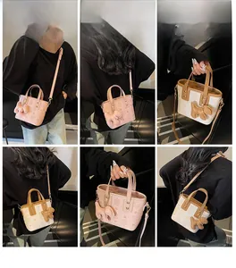 Multi-angle view of pink and brown embossed leather bucket bag with dog charm