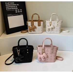 Detail of embossed mini bucket bags with star patterns and cute puppy charms in four colors