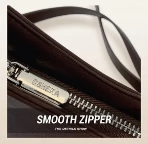 Close-up of premium smooth metal zipper with C&HEKA engraving on dark brown bucket bag