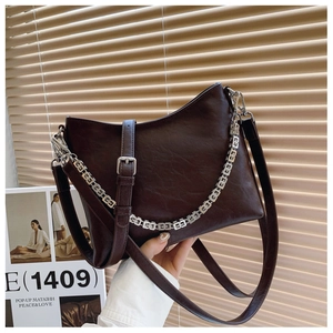 Detailed view of dark brown pebbled leather bag with distinctive silver chain strap