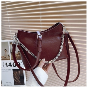 Deep burgundy leather bucket bag featuring a square geometric silver chain strap