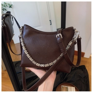 Detail view of deep brown leather bucket bag with rectangle hollow metal chain link