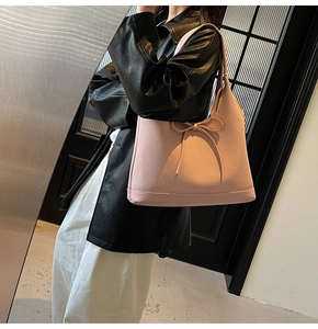 Close-up of pink tote bag showing textured twill fabric and decorative ribbon bow detail