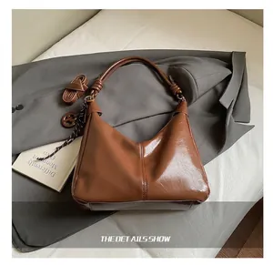 Détail du sac hobo marron vintage avec poignée à nœud et bandoulière amovible