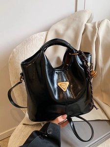 Vintage black glossy tote bag with gold metal plaque and woven bell pendant