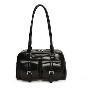 Macro view of black glossy patent leather shoulder bag with silver hardware buckles