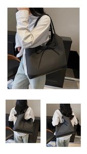 Detail of black woven tote bag with smooth leather patchwork and stylish bow decoration