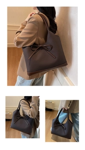 Detail view of large brown contrast tote bag with elegant bow accent and leather trim