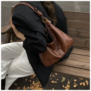 Grand sac cabas marron caramel avec détail de nœud porté par un mannequin en automne