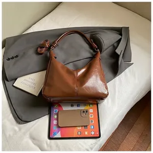 Gros plan d'un sac cabas vintage en cuir PU marron avec plis et poignée nouée