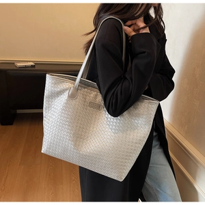Detailed view of silver woven texture tote bag with metallic finish and brand logo