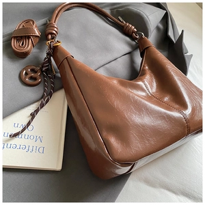 Détail d'un sac fourre-tout en cuir marron vintage avec nœud de corde et breloques