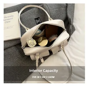 Spacious interior of off-white Boston bag showing daily essentials with zipper detail