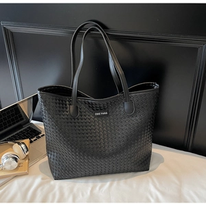 Detailed macro view of black woven faux leather texture and ZSKE PARIS brand label on tote