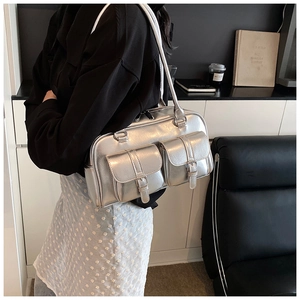 Detail of silver metallic shoulder bag featuring two front pockets and Y2K aesthetic design
