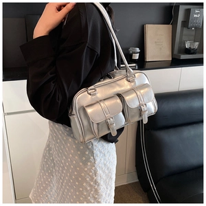 Detailed view of silver metallic shoulder bag with front buckle pockets and mirror finish