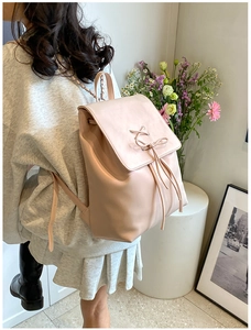 Minimalistischer rosa Damenrucksack aus Kunstleder mit Schleife getragen von einem Model