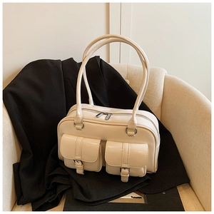 Detail of cream multi-pocket shoulder bag with metallic buckles and glossy PU finish