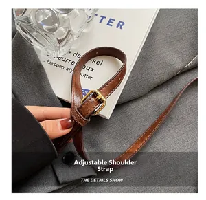 Gros plan sur la bandoulière en cuir réglable avec boucle dorée et coutures détaillées