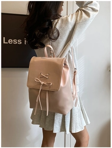 Rosafarbener Rucksack aus Kunstleder mit Schleife und Kordelzug am Model gezeigt
