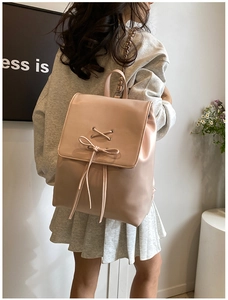 Detail eines rosa PU-Leder-Rucksacks mit Schleifenknoten, Kettenriff und Kordelzug