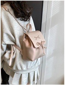 Detail eines rosa Kunstleder-Rucksacks mit Schnürung und Metallketten-Trägern