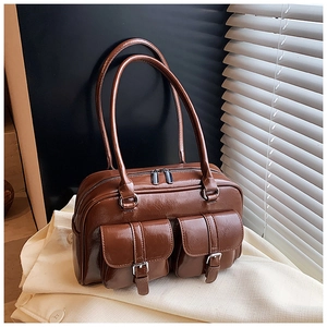 Detailed view of a vintage brown PU leather handbag with two functional front buckle pockets