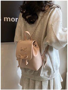 Detail eines rosa Mini-Rucksacks mit Leder-Kettenriemen und Schleifen-Dekoration
