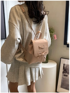 Detailansicht eines Mini-Rucksacks in Rosa mit Schleife und Goldkettenriemen