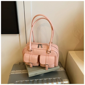 Pink glossy patent leather Boston bag detail with front flap pockets and silver hardware