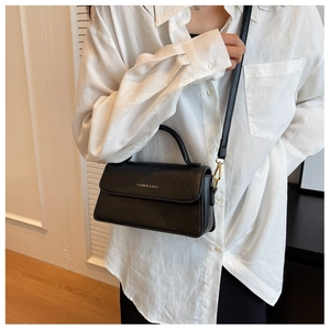 Détail d'un sac à bandoulière vintage en cuir noir avec logo FASHION & BAGS sur un mannequin