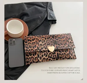 Détail de la pochette léopard en forme d'enveloppe avec boucle en métal doré en cœur