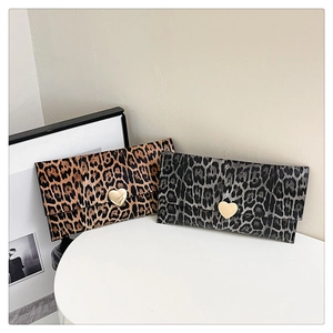Détail de pochettes enveloppes léopard avec de grandes boucles métalliques en forme de cœur