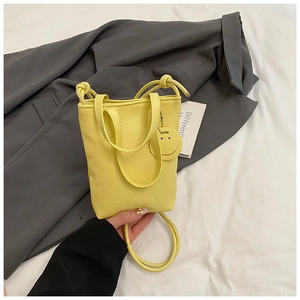 Close-up of yellow lychee pattern mini bucket bag with smile pendant and handle
