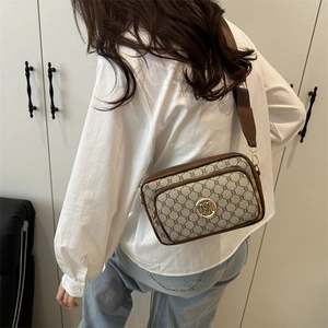 Vintage brown monogram crossbody bag with gold M logo and adjustable wide fabric strap