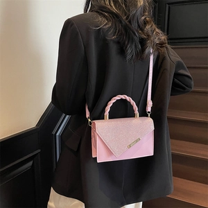Chic pink crossbody bag with glitter flap and woven handle for a stylish summer look