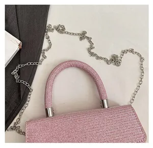 Detail of pink glitter handbag featuring a thick round handle and silver chain strap