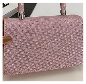 Detail of pink sequin texture and horizontal wave pattern on women's small square bag