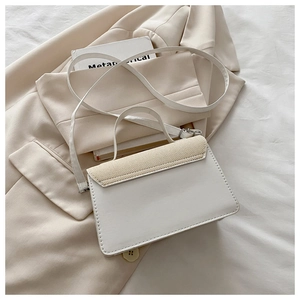 Detail of white leather and beige woven texture stitching on a modern square crossbody bag