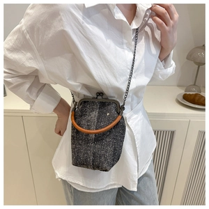Détail d'un sac bandoulière rétro en denim avec chaîne en métal et poignée en cuir